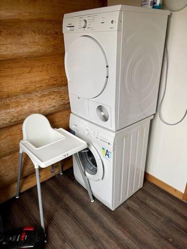 a washer and dryer in a room with a chair at Unieke houten villa met SAUNA in Twente - 6p in Den Ham