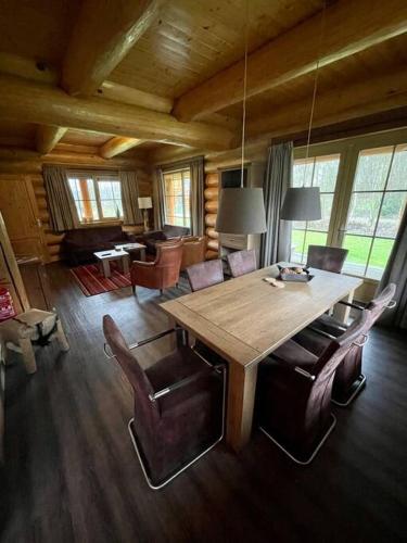 a dining room with a wooden table and chairs at Unieke houten villa met SAUNA in Twente - 6p in Den Ham