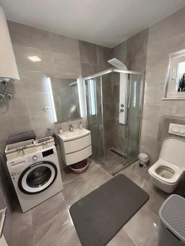 a bathroom with a washing machine and a toilet at Apartman Petra in Vir