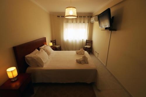 - une chambre avec un lit avec deux animaux rembourrés dans l'établissement Urban Beach - Apartamento Pôr do Sol, à Portimão