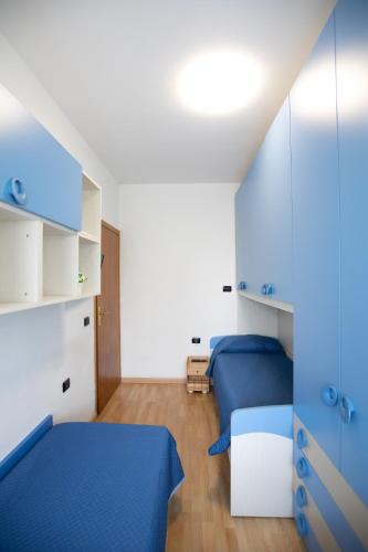 a small bedroom with two beds and blue sheets at Mirea's Rooms in Ascoli Piceno