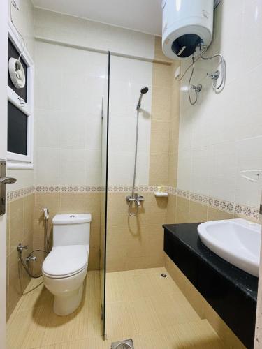 a bathroom with a toilet and a sink at Husin Al Khaleej Hotel Apartment in Seeb