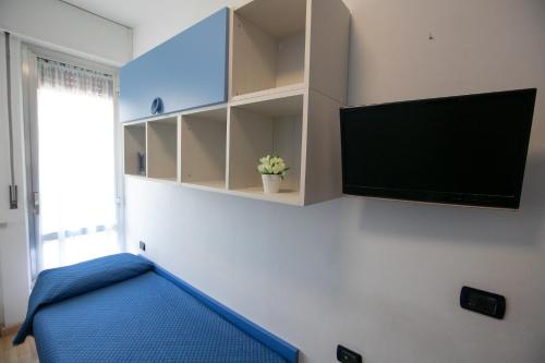 a living room with a tv and a blue couch at Mirea's Rooms in Ascoli Piceno