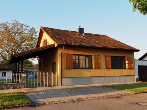 a yellow house with a fence in front of it at Ferienhaus Michi in St. Andrä am Zicksee