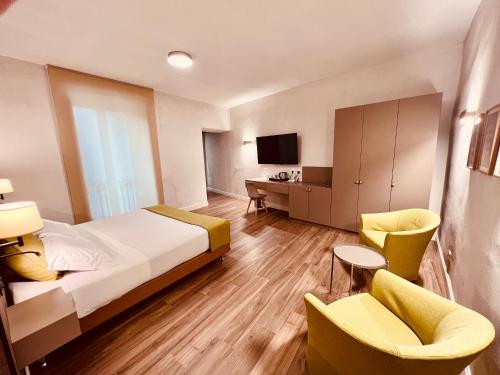 pokój hotelowy z łóżkiem i 2 krzesłami w obiekcie Gelsi Luxury Suites w mieście Sora