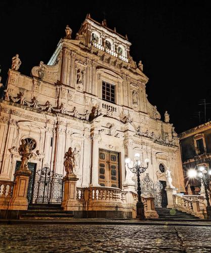 a large building at night with lights in front at La casa di Apollo in Acireale