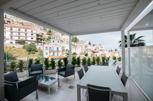 a balcony with a table and chairs and a view of the city at Taormina Art Apartment by Taormina Holidays in Taormina