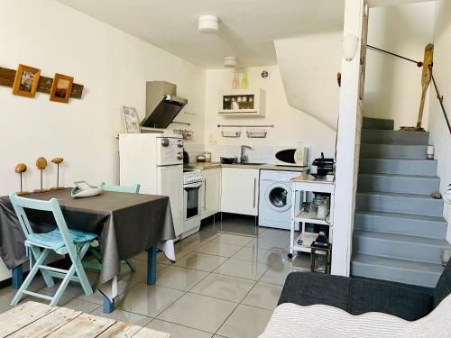 a kitchen and dining room with a table and a staircase at Paris-Sète T2 au coeur de Sète in Sète