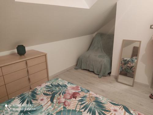 Schlafzimmer mit einem Bett, einer Kommode und einem Spiegel in der Unterkunft Family 2 in Changé