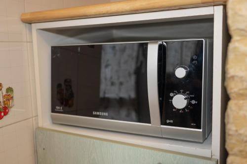 a microwave oven sitting on top of a shelf at Mirea's Rooms in Ascoli Piceno