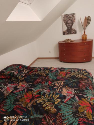een bed met een kleurrijk dekbed en een dressoir in een kamer bij Family 2 in Changé