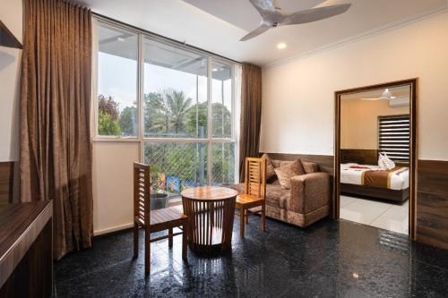 a hotel room with a table and a bedroom at Star Emirates Luxury Resort and Spa, Munnar in Anachal