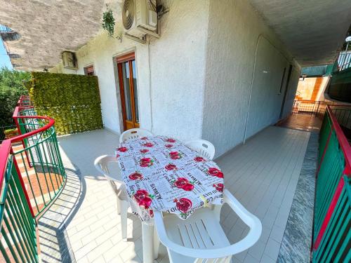 uma mesa branca com rosas vermelhas numa varanda em Soleado Apartments Caprioli-Palinuro em Palinuro