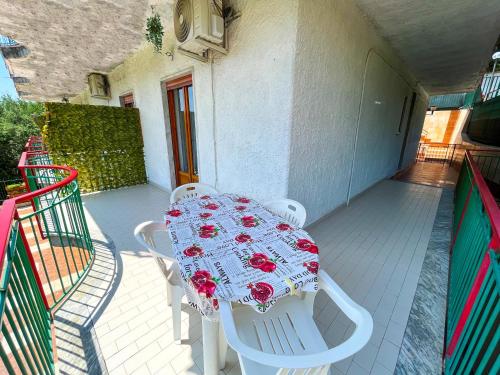 un tavolo bianco con rose rosse su un balcone di Soleado Apartments Caprioli-Palinuro a Palinuro