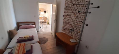 Kleines Zimmer mit 2 Betten und einer Wand in der Unterkunft Apartment Mezaroca in Rogoznica