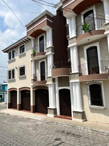 un gran edificio blanco con balcones en una calle en Amplio Apartamento, en Colonia Cerezos, Tercer nivel en Quetzaltenango