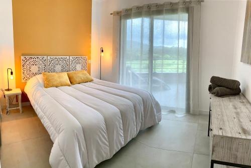 a bedroom with a large bed and a large window at Appart T3 4 étoiles 4/6 personnes Porto Vecchio in Porto-Vecchio