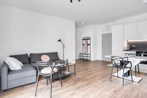een woonkamer met een bank, stoelen en een tafel bij Apartament Chwaliszewo in Poznań