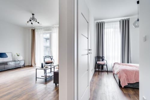 Cet appartement blanc comprend une chambre et un salon. dans l'établissement Apartament Chwaliszewo, à Poznań