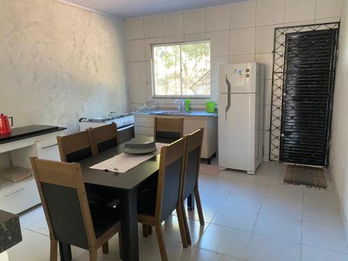 cocina con mesa, sillas y nevera en Casa em Aurora do Tocantins, en Manhã