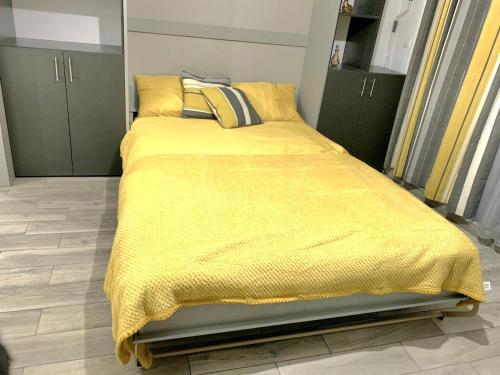a bedroom with a bed with a yellow blanket at Marina Cape surprise studio in Aheloy