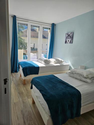 une chambre avec deux lits et une fenêtre dans l'établissement Chez Louise, Appartement T3 à deux pas du centre, à Luchon