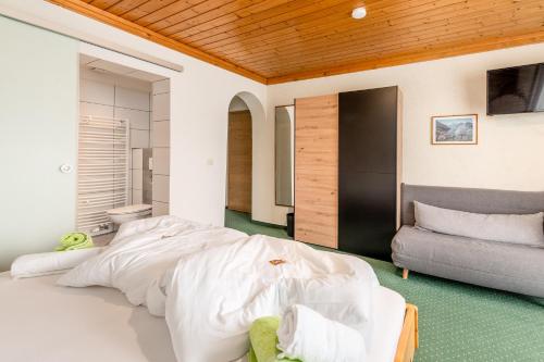 a bedroom with a large bed and a couch at Panoramahotel Stocker in Pruggern