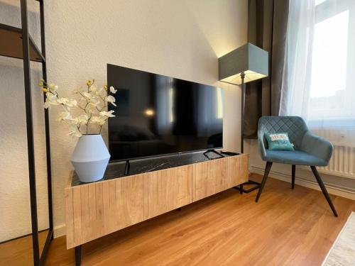 ein Wohnzimmer mit einem Flachbild-TV und einem Stuhl in der Unterkunft LUCKY STAYS LS09 - Vollausstattung - Zentrum - große Küche - 2 Zimmer - Smart-TV in Magdeburg