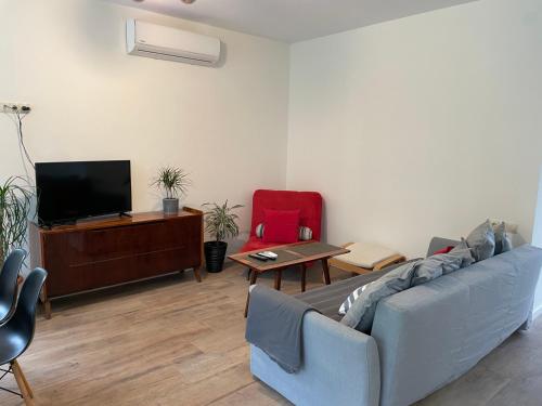 ein Wohnzimmer mit einem Sofa und einem TV in der Unterkunft Villa Mountview in Gonio