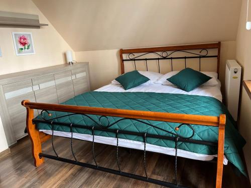 - une chambre dotée d'un lit avec des draps verts et blancs dans l'établissement Zatoczka Turawa, à Turawa