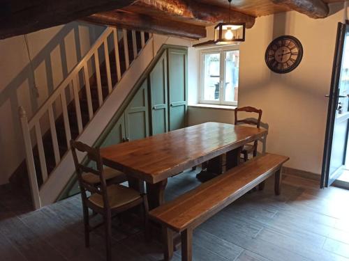 a wooden table and bench in a room with stairs at Le Nid de Laly in Ustou