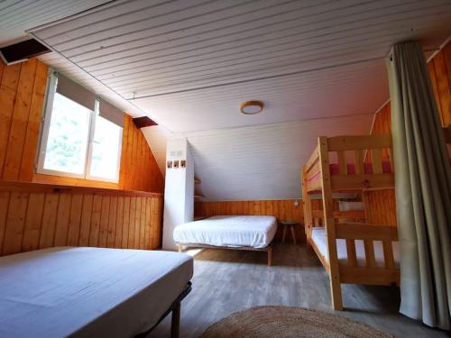 une chambre avec un lit et une chaise dans une pièce dans l'établissement Le Nid de Laly, à Ustou