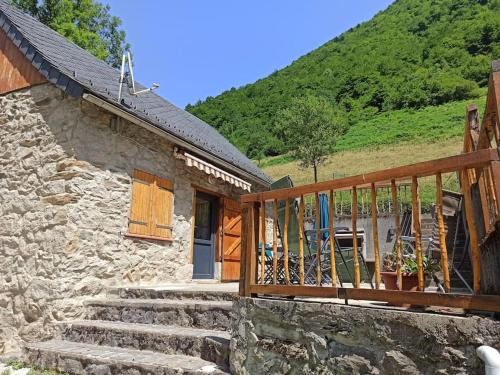 une maison en pierre avec des escaliers et un balcon en bois dans l'établissement Le Nid de Laly, à Ustou