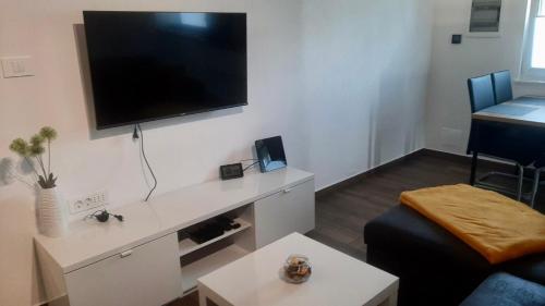 sala de estar con TV de pantalla plana grande en la pared en Apartma Lima en Ankaran