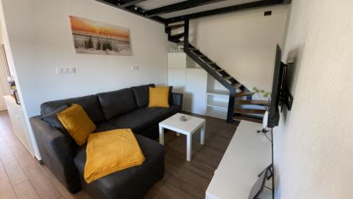 a living room with a black couch and a television at Apartma Lima in Ankaran