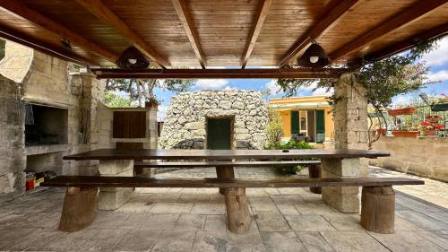 a wooden picnic table sitting under a pavilion at La Chiesura in Galugnano