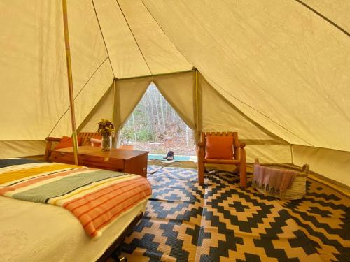 a bedroom with a tent with a desk and a chair at Sailor Springs Glamping in Bayfield