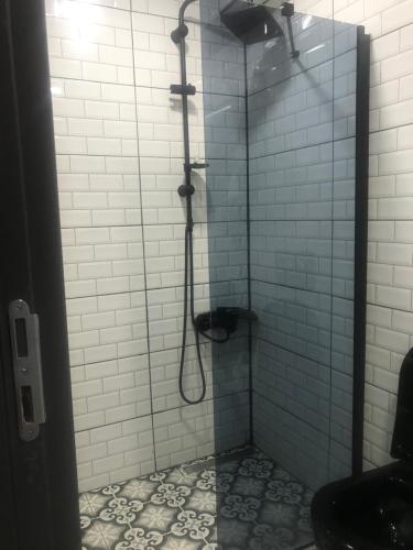 een douche in een badkamer met blauwe tegels bij Hotel Hoyuk in Istanbul