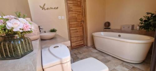 a bathroom with a tub and a toilet and a sink at Villa centre Grand Baie in Grand Baie