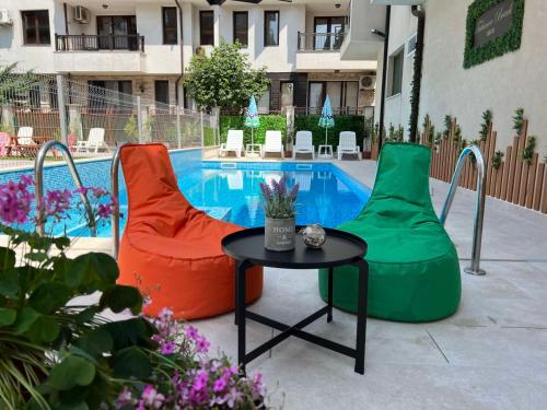 ソゾポルにあるTabanov Beach Hotelのプールの前に椅子2脚とテーブル1台