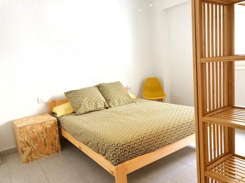 a bedroom with a bed and a yellow chair at Bonito apartamento en Castellón in Castellón de la Plana