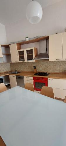 a kitchen with white cabinets and a red stove at Týnská ulicka 2 - Cathedral View Apartment in Prague