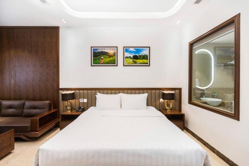 a hotel room with a bed and a couch at Blubiz Hotel Mỹ Đình (Blubiz Hotel 2) in Hanoi
