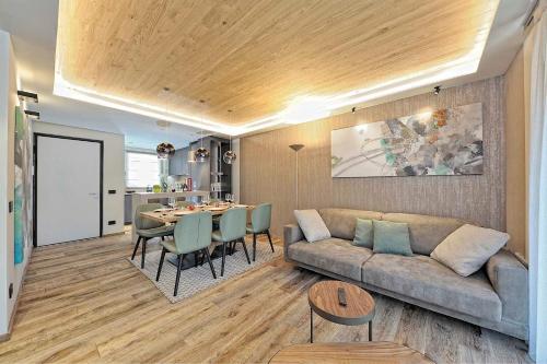 a living room with a couch and a table at Lux Domotic Apt-Chalet Dolomites in Pinzolo