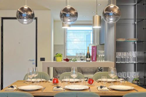 a dining room with a table with chairs and wine glasses at Lux Domotic Apt-Chalet Dolomites in Pinzolo