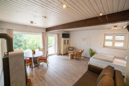 a living room with a bed and a table in a room at Ferienhaus Rhön-Auszeit in Bischofsheim an der Rhön