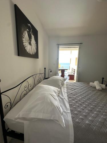 a white bedroom with a bed with a view of the ocean at Apartments Alać in Drasnice