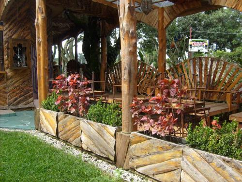 a wooden pavilion with chairs and flowers in a garden at Casa Antigua Hotel in Alajuela City