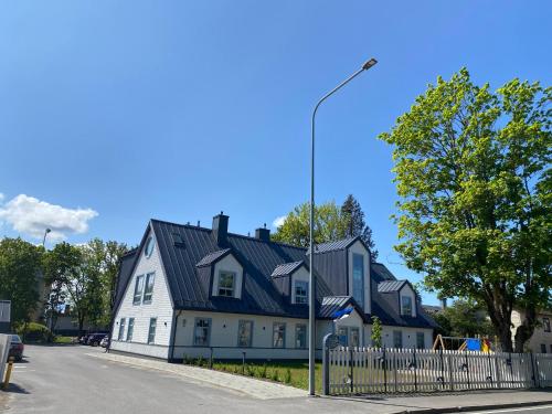 a large white house with a black roof at Modern Central Apartment HOTEL in Keyla