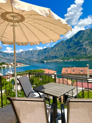 d'une table, de chaises et d'un parasol sur le balcon. dans l'établissement Lobov view, à Kotor